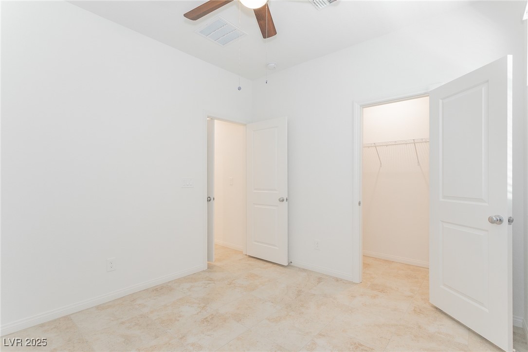 3468 Bradano Lane Henderson, NV 89044 - Photo 7 of 50 Unfurnished bedroom featuring a walk in closet and a ceiling fan