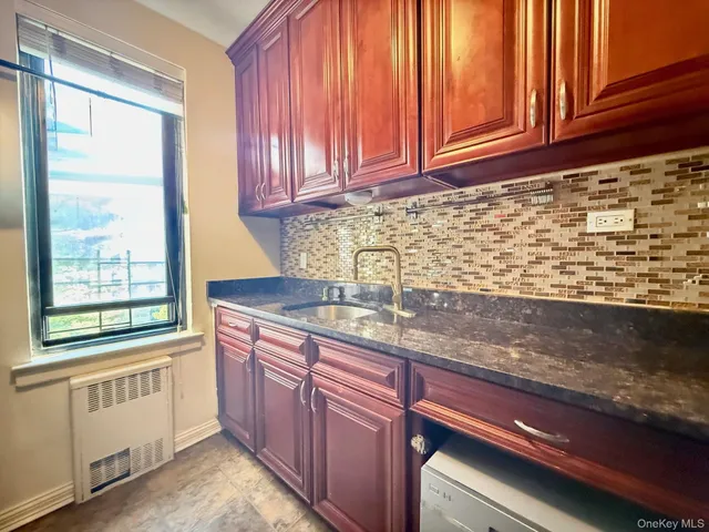 a kitchen with granite countertop cabinets stainless steel appliances a sink and window