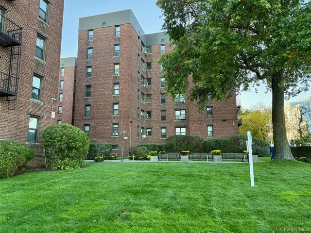 a view of a tall building next to a yard