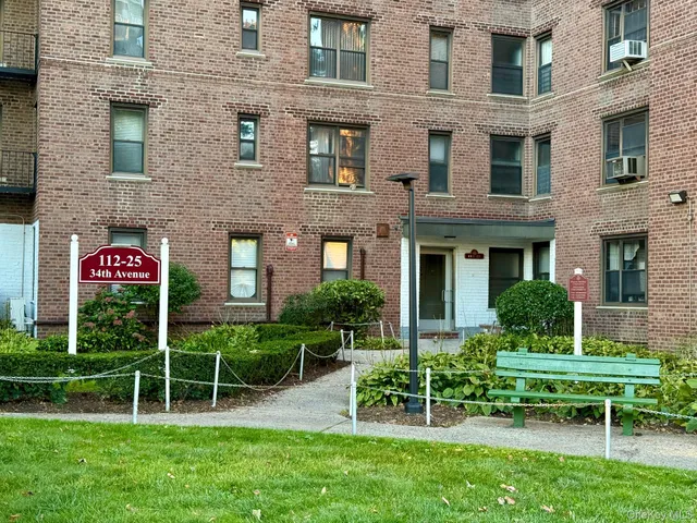 a view of a brick house with a yard table and chairs