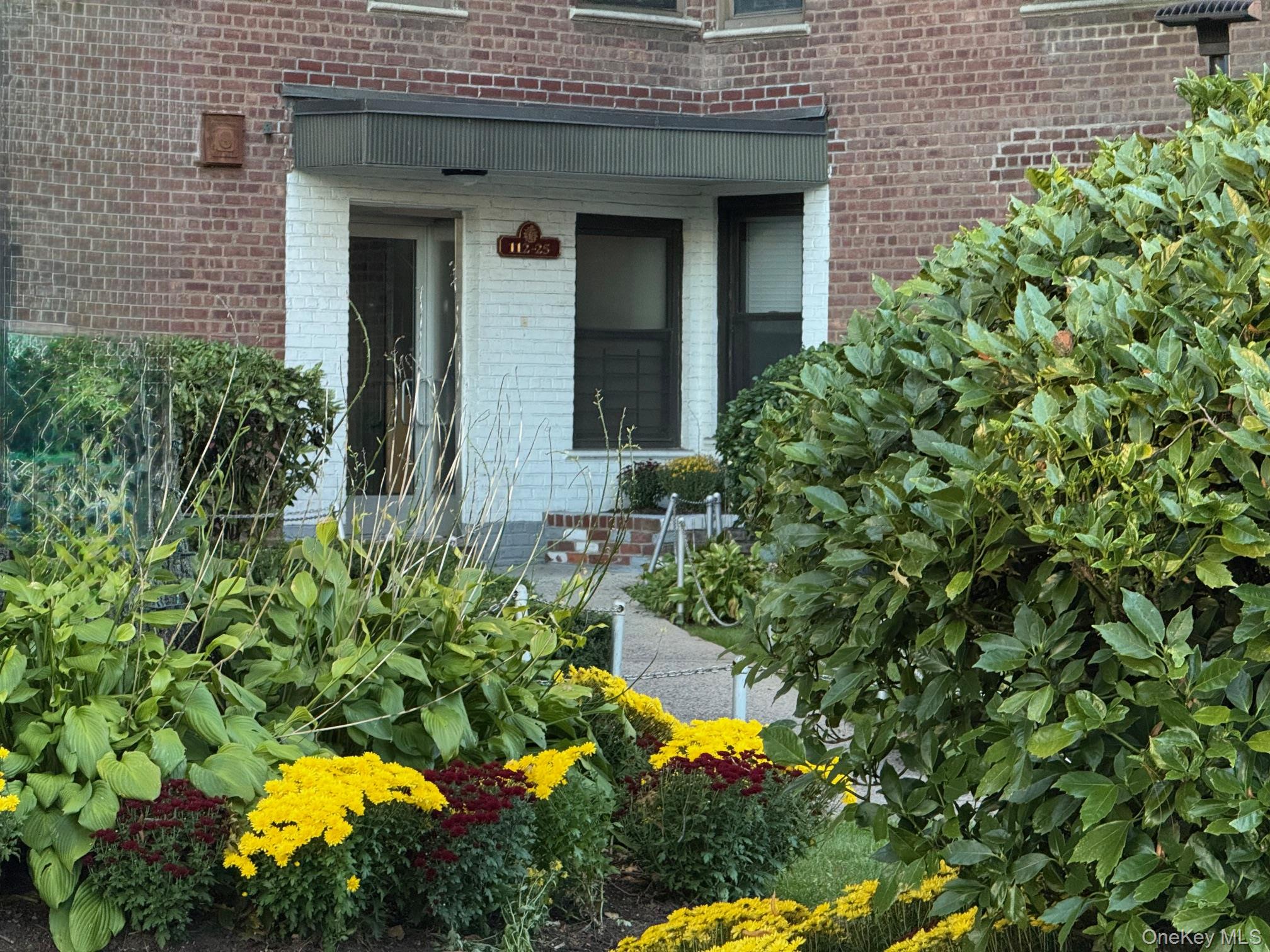112-25 34th Avenue, Unit 3E Queens, NY 11368 - Photo 28 of 33 view of a house with a flower garden