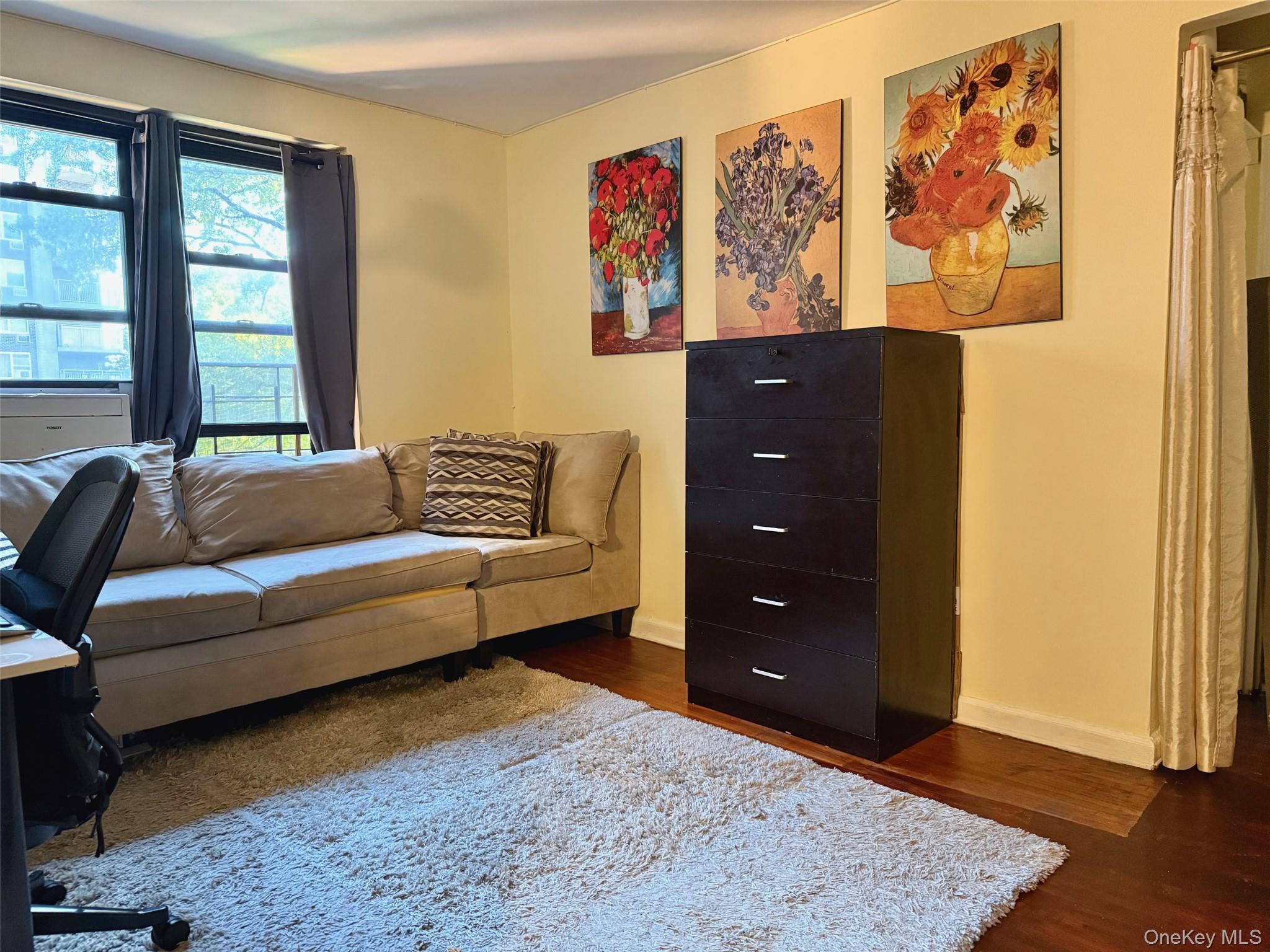 112-25 34th Avenue, Unit 3E Queens, NY 11368 - Photo 3 of 33 a bedroom with a bed and wooden floor