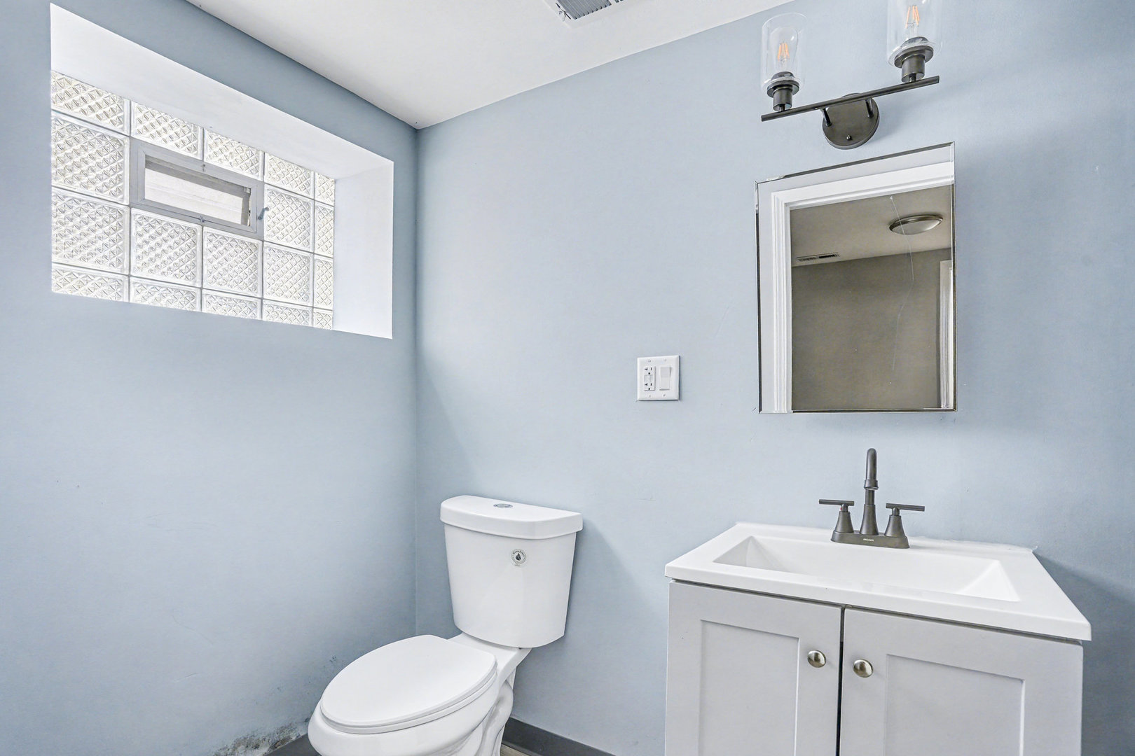 7449 South Bennett Avenue Chicago, IL 60649 - Photo 13 of 15 a bathroom with a toilet sink and mirror