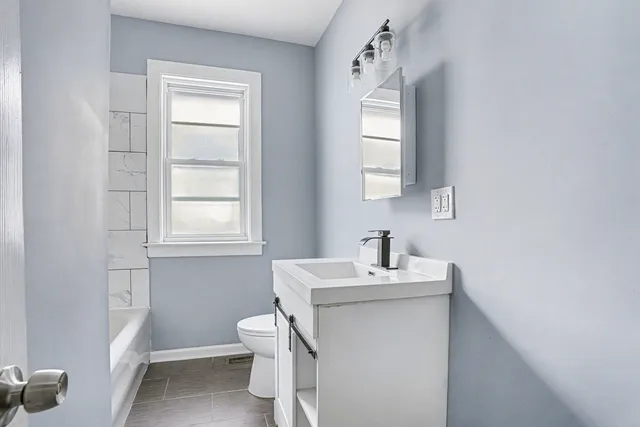 a bathroom with a sink toilet and mirror