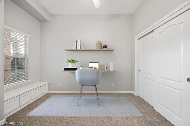 a view of a workspace with furniture and a window