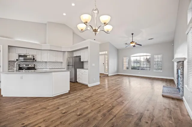 a view of a kitchen with wooden floor and a large window