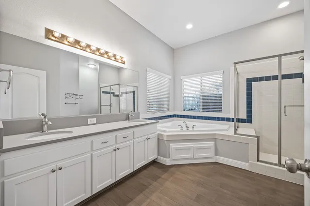a bathroom with a tub a sink and mirror