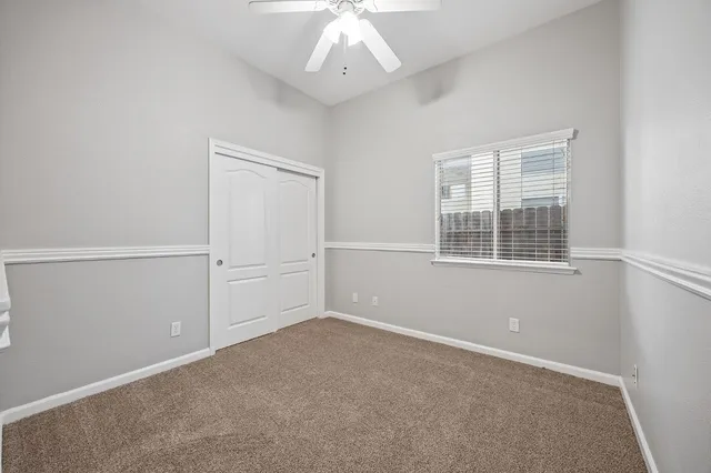 an empty room with chandelier fan