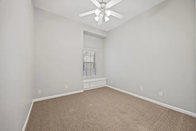 an empty room with a chandelier fan