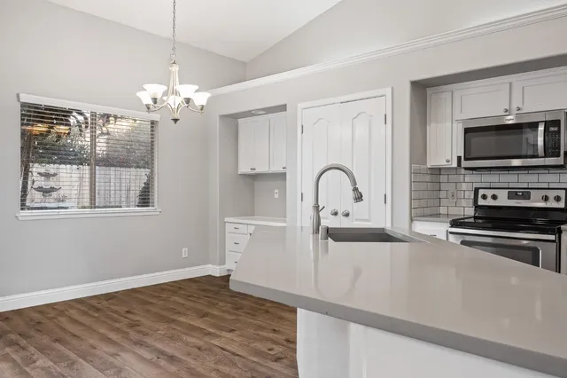 a kitchen with stainless steel appliances kitchen island granite countertop a stove a sink and a microwave