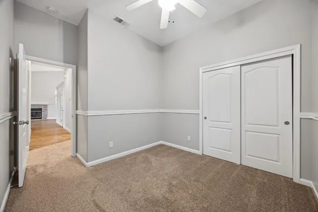 an empty room with chandelier fan