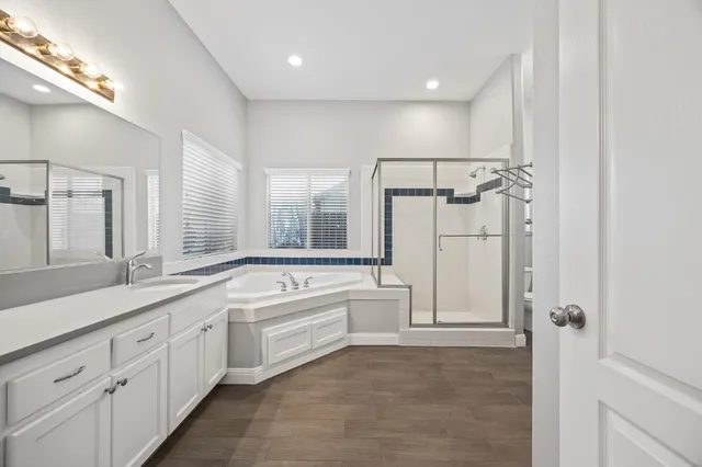 a spacious bathroom with a tub sink shower and mirror