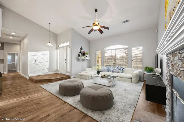 a living room with fireplace furniture and a large window