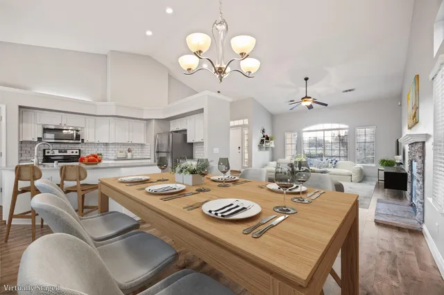 a view of a dining room and livingroom with furniture wooden floor and a chandelier