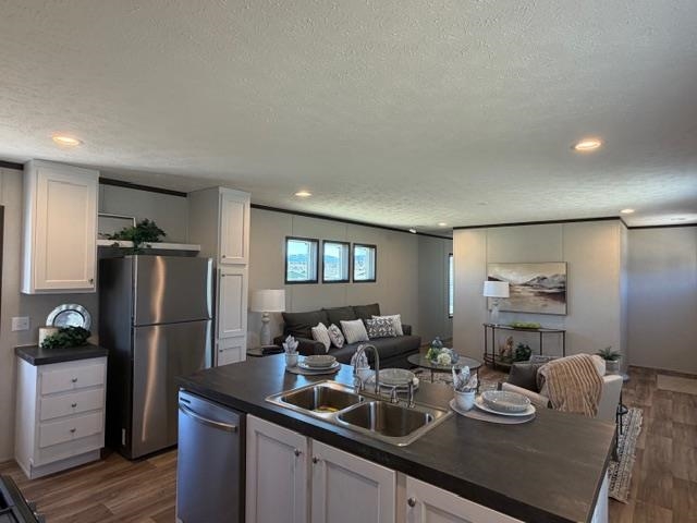 200 West 20th Street, Unit A138 Rifle, CO 81650 - Photo 6 of 7 a kitchen with refrigerator and chairs