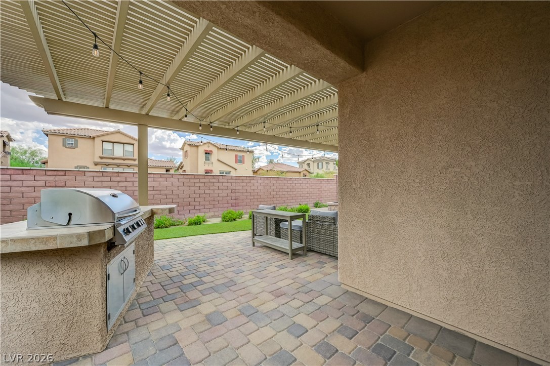 7049 Motley Road Las Vegas, NV 89178 - Photo 45 of 61 An inviting covered patio features integrated cooking facilities and paved flooring.