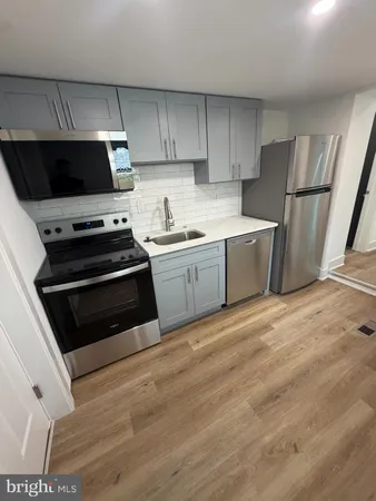 a kitchen with a stove a refrigerator and a sink
