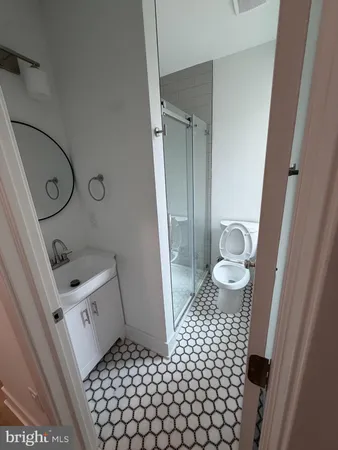 a bathroom with a sink a toilet a mirror and shower