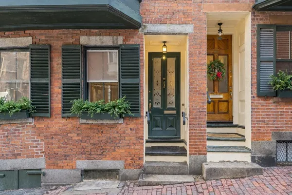 a front view of a house with a potted plant