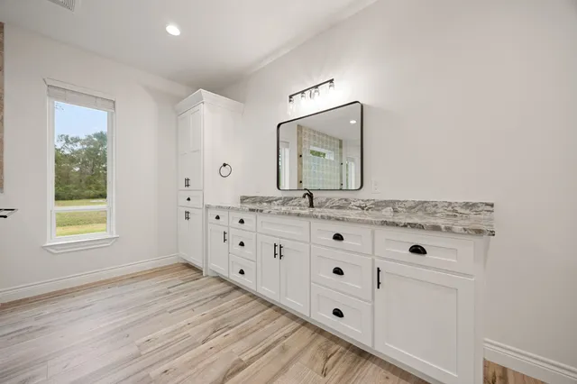 a bathroom with a granite countertop sink and a mirror