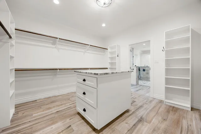 a room with white cabinets and wooden floor