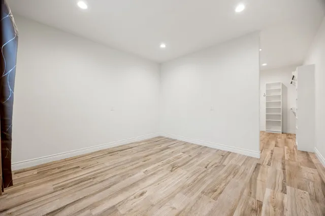 a view of empty room with wooden floor
