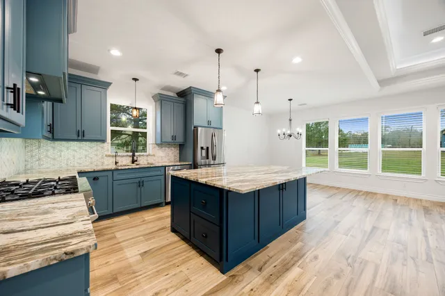 a kitchen with kitchen island granite countertop wooden cabinets and white appliances