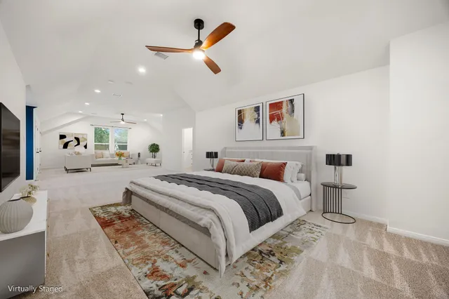 a spacious bedroom with a bed a couch and a chandelier