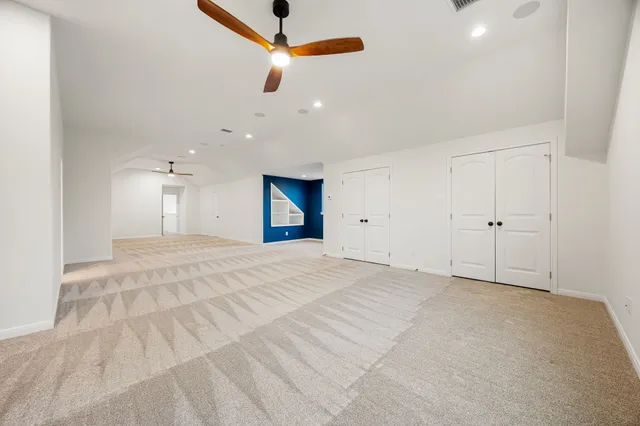 a view of an empty room with a ceiling fan