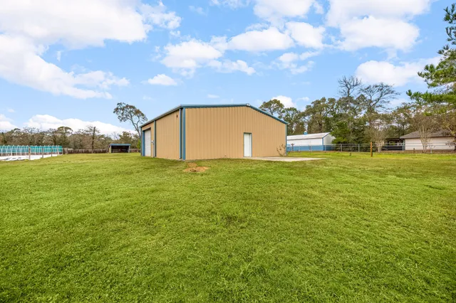 a front view of house with yard and trees in the background