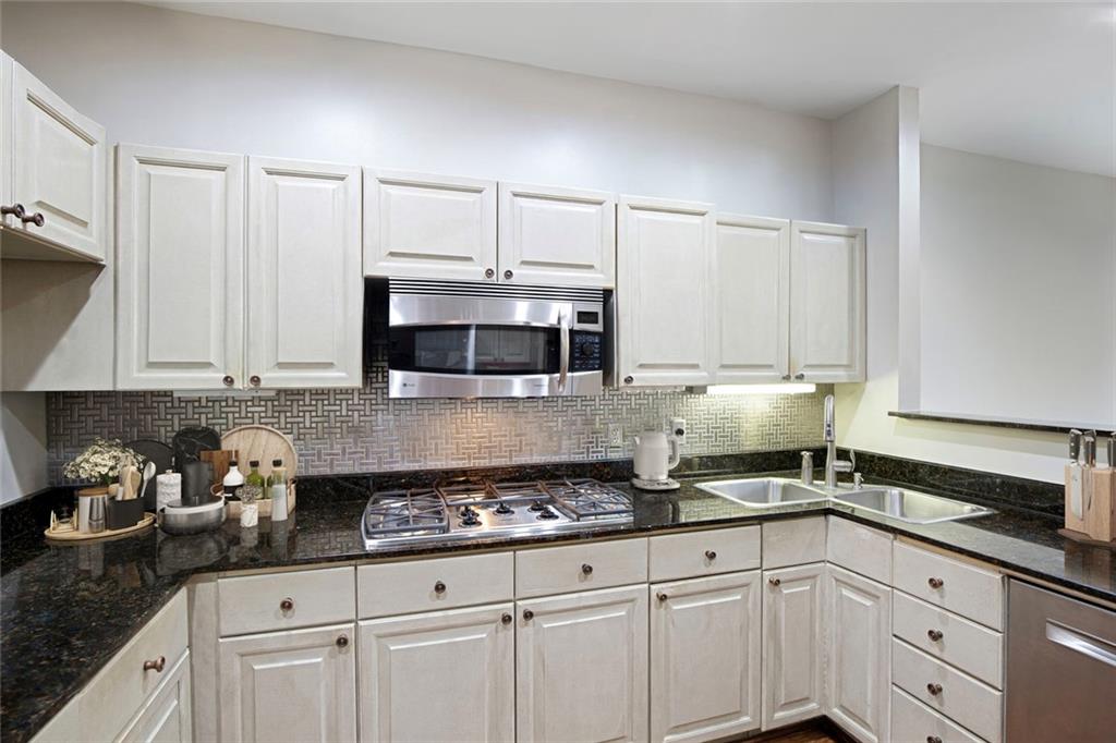 5264 Brooke Ridge Drive Dunwoody, GA 30338 - Photo 11 of 34 a kitchen with granite countertop white cabinets and white appliances