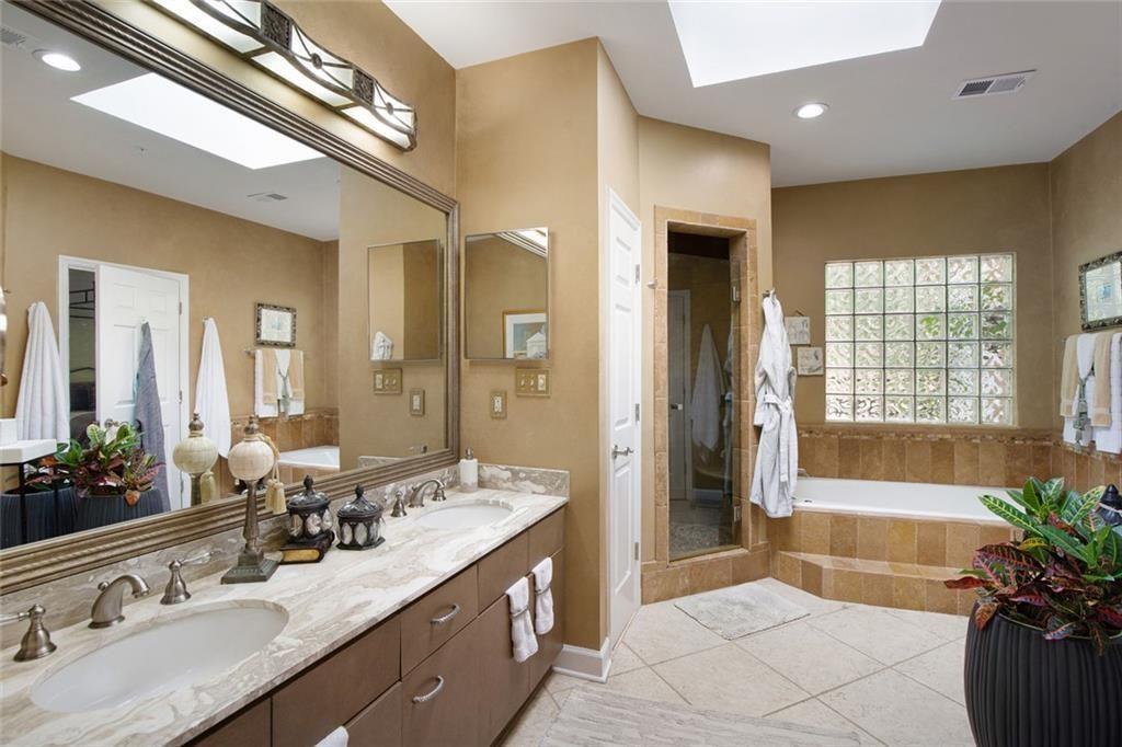 5264 Brooke Ridge Drive Dunwoody, GA 30338 - Photo 17 of 34 a spacious bathroom with a double vanity sink a large mirror a bathtub and next to a window