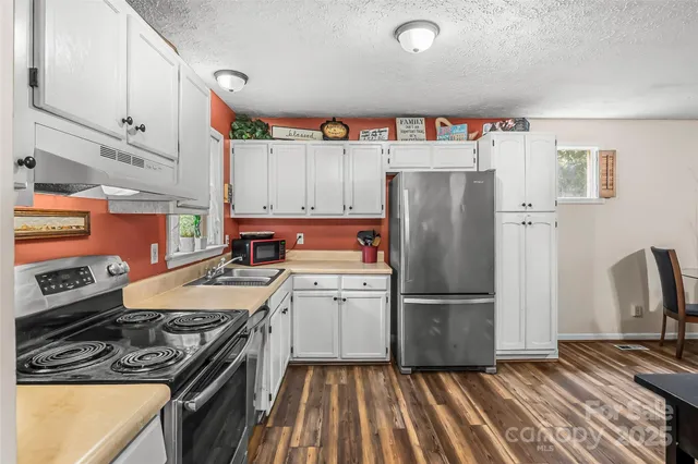 a kitchen with a refrigerator and a stove top oven