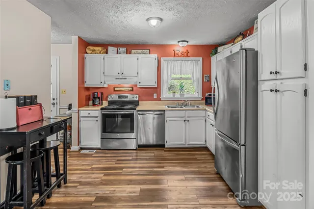 a kitchen with stainless steel appliances a stove sink and refrigerator