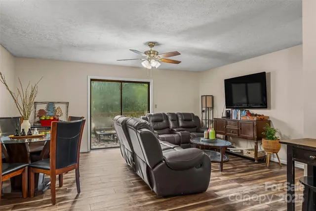 a living room with furniture a flat screen tv and a floor to ceiling window