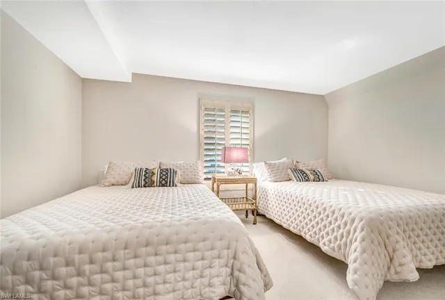 a bedroom with two bed and a night stand