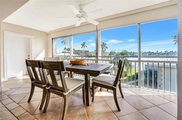 a dining room with furniture a chandelier and a floor to ceiling window