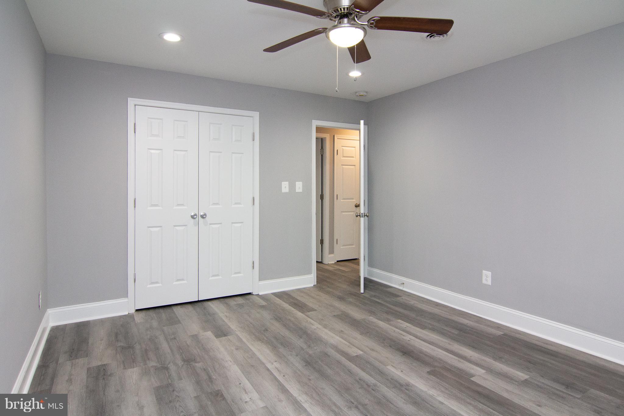 1934 Winder Road Windsor Mill, MD 21244 - Photo 22 of 31 an empty room with a ceiling fan and wooden floor