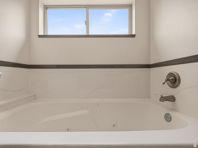 1279 West 1500th Street North Mapleton, UT 84664 - Photo 45 of 83 Jetted soaking tub featuring white acrylic, integrated armrests, and a brushed metal faucet