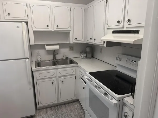 a kitchen with white cabinets and white appliances