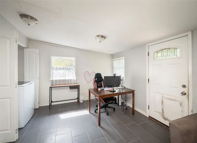 a view of a workspace with furniture and a window