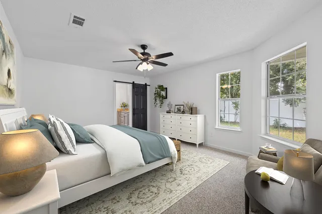 a bedroom with a bed couch and window