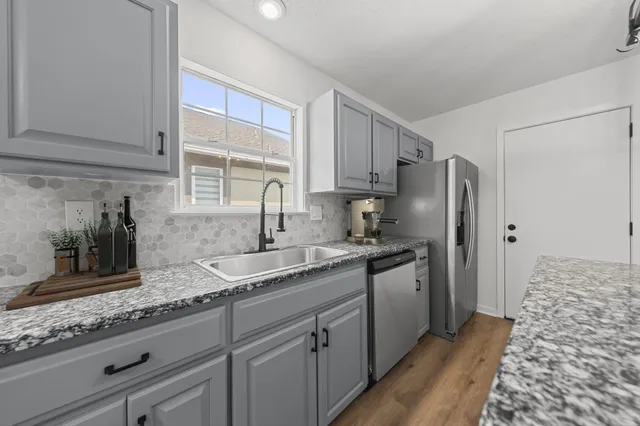 a kitchen with stainless steel appliances granite countertop a sink stove and refrigerator