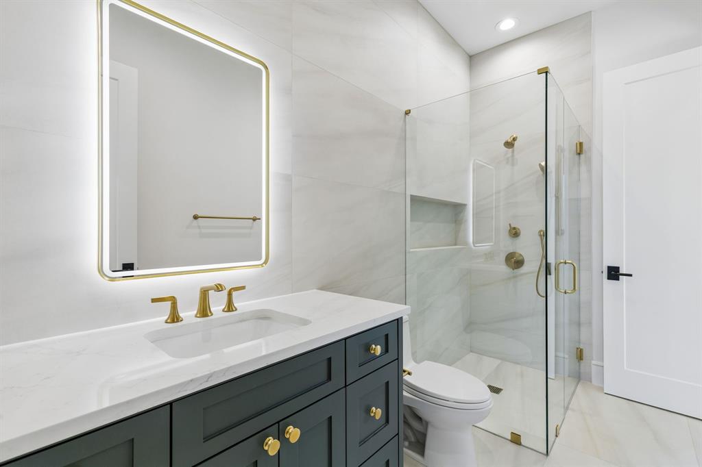 6215 Lafayette Way Dallas, TX 75230 - Photo 24 of 36 a bathroom with a sink a toilet and shower