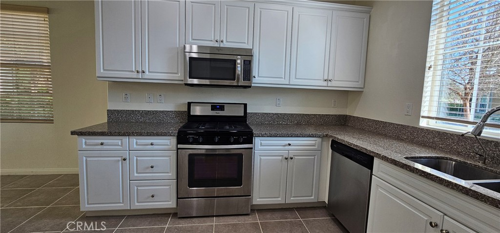 8652 Cava Drive Rancho Cucamonga, CA 91730 - Photo 12 of 44 a kitchen with stainless steel appliances granite countertop a stove microwave and cabinets
