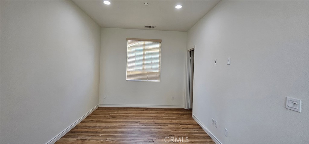8652 Cava Drive Rancho Cucamonga, CA 91730 - Photo 19 of 44 a view of an empty room with wooden floor and a window
