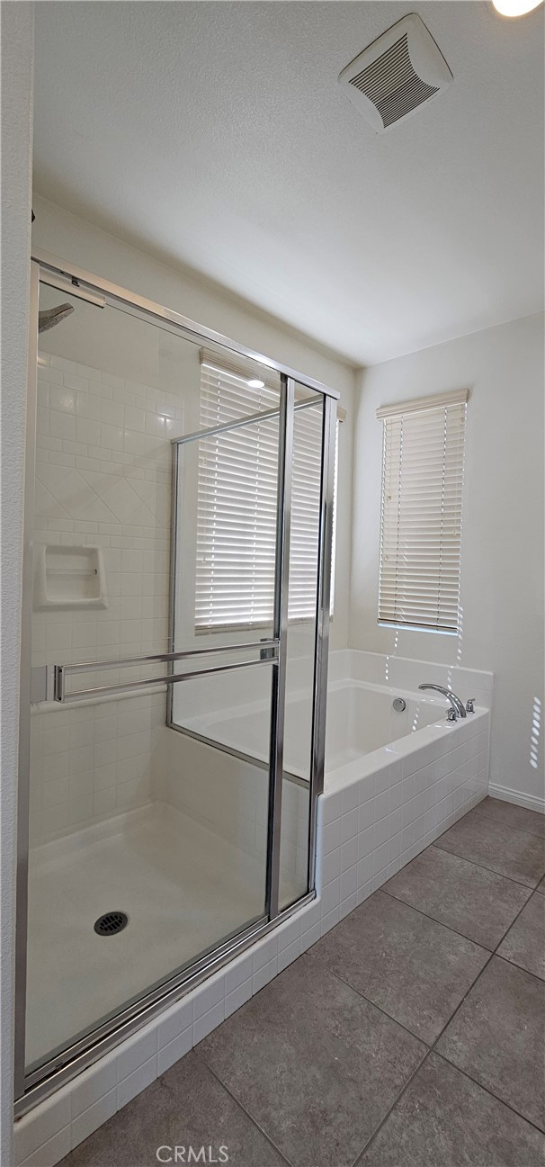 8652 Cava Drive Rancho Cucamonga, CA 91730 - Photo 27 of 44 a bathroom with a bathtub and a shower