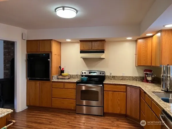 a kitchen with stainless steel appliances granite countertop a stove a sink and a refrigerator