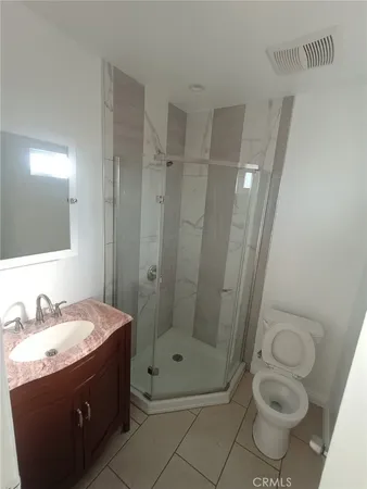 a bathroom with a granite countertop sink toilet and shower