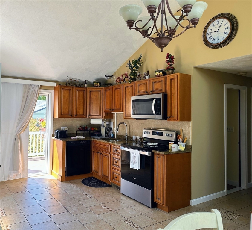 4 Mersea Street Saugus, MA 01906 - Photo 11 of 28 a kitchen with stainless steel appliances granite countertop a stove top oven a sink a refrigerator and a microwave